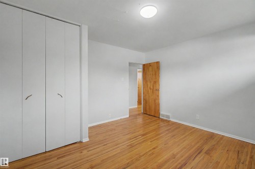 Room featuring wood-finish flooring, white walls, and a ceiling-mounted light fixture - 8215 149 Street Nw, Edmonton, AB - Indoor Photo Showing Other Room