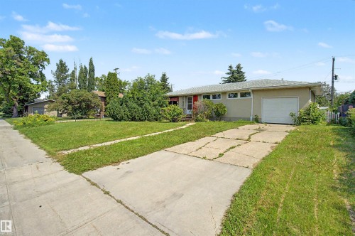 Ranch-style exterior with an attached single-car garage, a concrete driveway, and a red entry door - 8215 149 Street Nw, Edmonton, AB - Outdoor