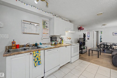 Kitchenette featuring white cabinetry, a double basin sink, and a white electric range - 8215 149 Street Nw, Edmonton, AB - Indoor Photo Showing Kitchen With Double Sink