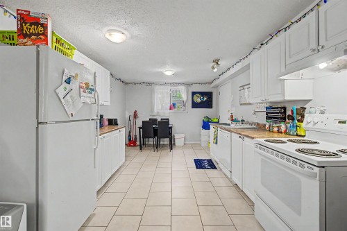 Kitchen with white cabinetry, light countertops, and tile flooring - 8215 149 Street Nw, Edmonton, AB - Indoor Photo Showing Kitchen