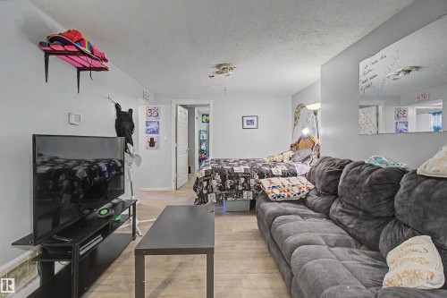 Open-concept room featuring light-colored walls and wood-finish flooring - 8215 149 Street Nw, Edmonton, AB - Indoor