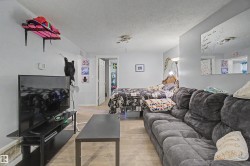 Open-concept room featuring light-colored walls and wood-finish flooring - 