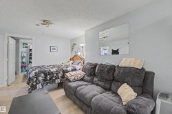 Light-toned wood-finish flooring extends throughout this versatile space, complemented by neutral wall paint - 