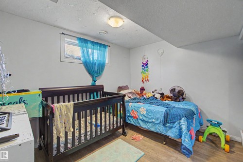 Room featuring a window, wood-finish flooring, and a ceiling-mounted light fixture - 8215 149 Street Nw, Edmonton, AB - Indoor Photo Showing Bedroom