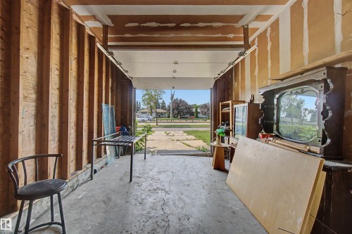 Garage interior featuring exposed wood studs and concrete flooring - 8215 149 Street Nw, Edmonton, AB - Indoor