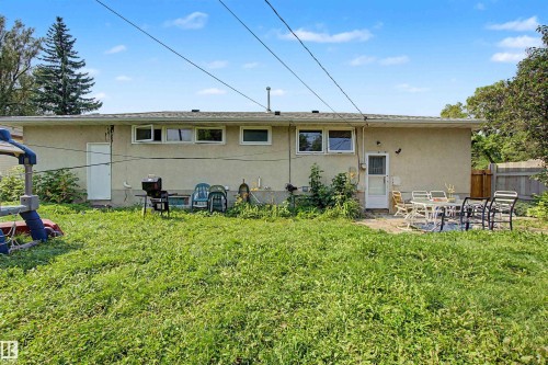 Expansive backyard featuring a large green space, a paved patio area, and a privacy fence - 8215 149 Street Nw, Edmonton, AB - Outdoor