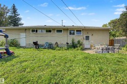 Expansive backyard featuring a large green space, a paved patio area, and a privacy fence - 