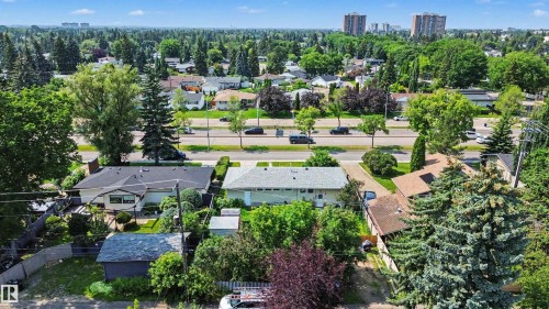 Aerial perspective showcasing a residential property with surrounding mature trees and a prominent street - 8215 149 Street Nw, Edmonton, AB - Outdoor With View