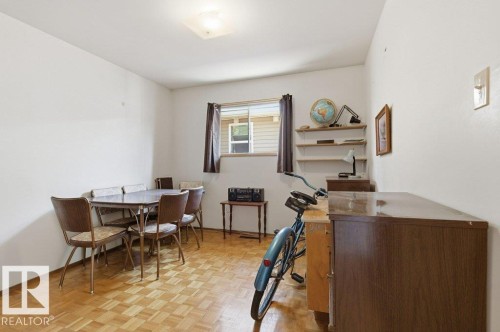 Room featuring wood-finish parquet flooring and a single window with blinds - 10459 66 Avenue Nw, Edmonton, AB - Indoor