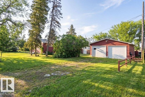 Detached two-car garage with white paneled doors and red siding - 10459 66 Avenue Nw, Edmonton, AB - Outdoor