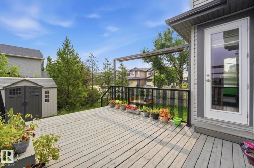 Expansive wood-finish deck with black metal railing and a built-in storage shed - 1051 174 Street Sw, Edmonton, AB - Outdoor With Deck Patio Veranda With Exterior