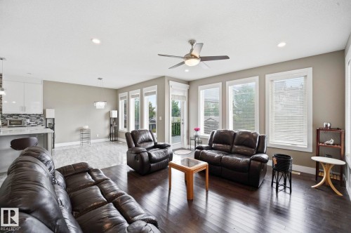 Expansive living area featuring rich wood-finish flooring, a contemporary ceiling fan, and recessed lighting - 1051 174 Street Sw, Edmonton, AB - Indoor Photo Showing Living Room