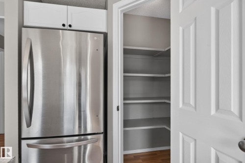 Stainless steel refrigerator with a bottom freezer and overhead white cabinetry - 8923 173 Avenue Nw, Edmonton, AB - Indoor
