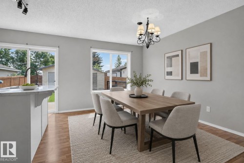 Open dining area featuring wood-finish flooring and a decorative chandelier - 8923 173 Avenue Nw, Edmonton, AB - Indoor Photo Showing Dining Room