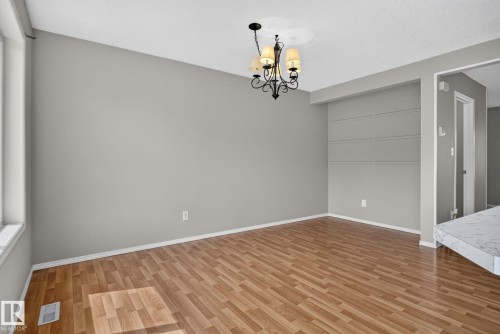 Open concept room featuring wood-finish flooring and a decorative chandelier - 8923 173 Avenue Nw, Edmonton, AB - Indoor Photo Showing Other Room