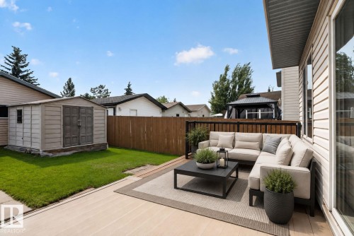 Backyard deck featuring composite decking, a black metal and wood privacy fence, and a storage shed - 8923 173 Avenue Nw, Edmonton, AB - Outdoor With Exterior