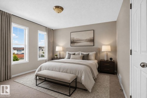 Bedroom featuring two large windows with white trim, neutral carpeting, a built-in light fixture, and a paneled door - 8923 173 Avenue Nw, Edmonton, AB - Indoor Photo Showing Bedroom