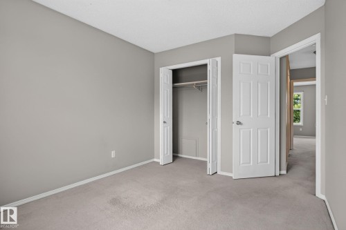 Carpeted room featuring light gray walls, white trim, a bi-fold closet, and a white six-panel door - 8923 173 Avenue Nw, Edmonton, AB - Indoor Photo Showing Other Room