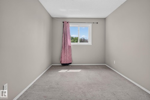 Neutral gray wall paint with white trim, gray carpet flooring, and a single window - 8923 173 Avenue Nw, Edmonton, AB - Indoor Photo Showing Other Room