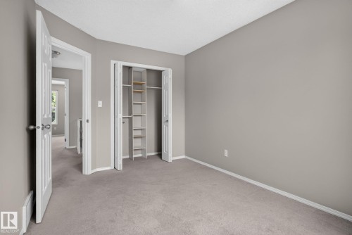 Neutral-toned room featuring a soft gray carpet, light gray wall paint, and white baseboards - 8923 173 Avenue Nw, Edmonton, AB - Indoor Photo Showing Other Room