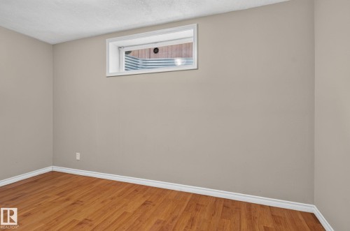 Neutral-toned walls with white trim and wood-finish flooring - 8923 173 Avenue Nw, Edmonton, AB - Indoor Photo Showing Other Room