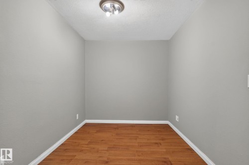 Room featuring light gray walls, wood-finish flooring, white baseboards, and a flush-mount ceiling light fixture - 8923 173 Avenue Nw, Edmonton, AB - Indoor Photo Showing Other Room