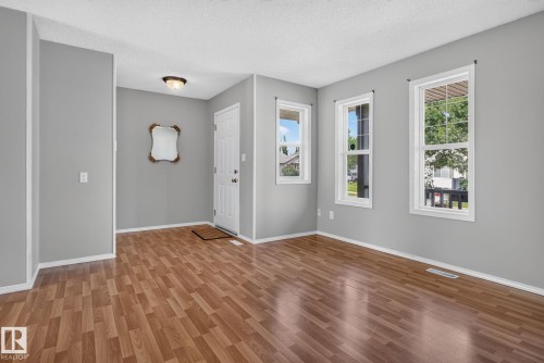 Open concept living area featuring wood-finish flooring and light gray walls - 8923 173 Avenue Nw, Edmonton, AB - Indoor Photo Showing Other Room