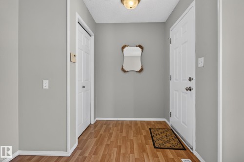 Entryway featuring wood-finish flooring, light gray wall color, white trim, and a white paneled door - 8923 173 Avenue Nw, Edmonton, AB - Indoor Photo Showing Other Room