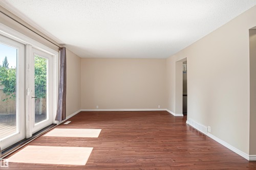 Spacious interior room featuring rich wood-finish flooring and neutral painted walls - 281 Vantage Lane, Sherwood Park, AB - Indoor Photo Showing Other Room