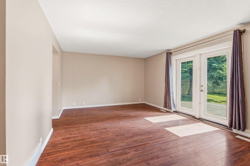 Spacious room featuring wood-finish flooring, neutral-toned walls, and a textured ceiling - 281 Vantage Lane, Sherwood Park, AB - Indoor Photo Showing Other Room