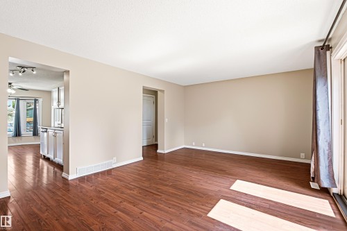 Spacious living area featuring wood-finish flooring, neutral wall tones, and white baseboards - 281 Vantage Lane, Sherwood Park, AB - Indoor Photo Showing Other Room