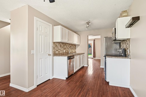 Kitchen featuring white cabinetry, stone-finish countertops, and a mosaic tile backsplash - 281 Vantage Lane, Sherwood Park, AB - Indoor Photo Showing Kitchen