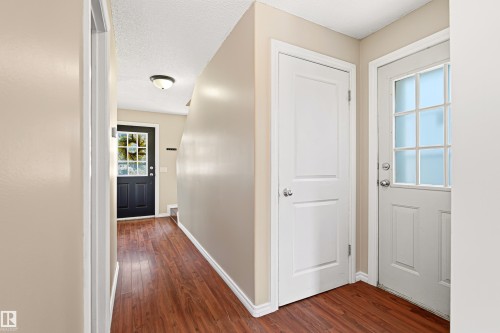 Entryway featuring wood-finish flooring, two panel interior doors, and a front entry door with integrated window panes - 281 Vantage Lane, Sherwood Park, AB - Indoor Photo Showing Other Room