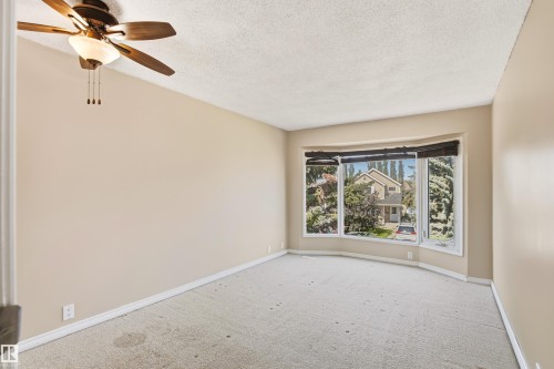 Spacious room featuring a bay window, ceiling fan with integrated lighting, neutral wall paint, and light-colored carpeting - 281 Vantage Lane, Sherwood Park, AB - Indoor Photo Showing Other Room