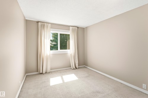 Neutral-toned room featuring a large window, light beige wall paint, white trim, and light-colored carpeting - 281 Vantage Lane, Sherwood Park, AB - Indoor Photo Showing Other Room