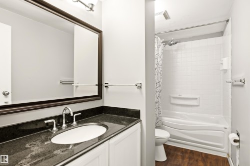Bathroom featuring a white vanity with a dark stone countertop and undermount sink, a framed mirror, and a full bathtub with white subway tile surround and shower fixture - 281 Vantage Lane, Sherwood Park, AB - Indoor Photo Showing Bathroom