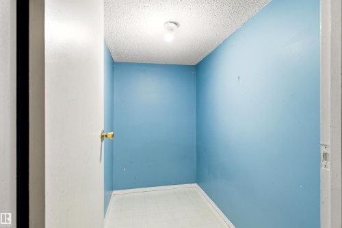 Compact interior space featuring blue painted walls, white baseboards, and a white ceiling with a textured finish - 281 Vantage Lane, Sherwood Park, AB - Indoor Photo Showing Other Room