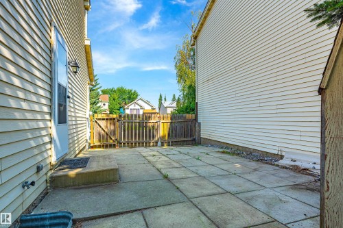 Patio area featuring large concrete pavers, a wooden privacy fence, and light-toned siding - 281 Vantage Lane, Sherwood Park, AB - Outdoor