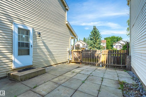 Inviting patio space featuring large-format pavers, low-maintenance gravel borders, and wooden deck access - 281 Vantage Lane, Sherwood Park, AB - Outdoor