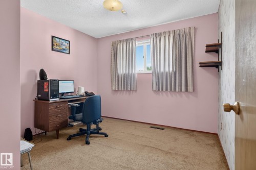 Carpeted room with a window providing natural light, a ceiling-mounted light fixture, and built-in wall shelving - 6012 145 Avenue Nw, Edmonton, AB - Indoor Photo Showing Office