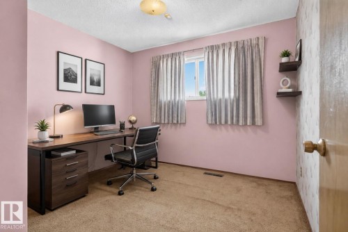 Windowed room with a low-pile carpet flooring, a textured popcorn ceiling, and a flush-mount ceiling light fixture - 6012 145 Avenue Nw, Edmonton, AB - Indoor Photo Showing Office