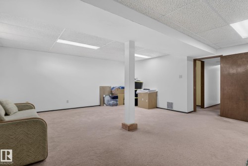 Finished lower level with neutral carpet, white walls, and drop ceiling with recessed lighting - 6012 145 Avenue Nw, Edmonton, AB - Indoor
