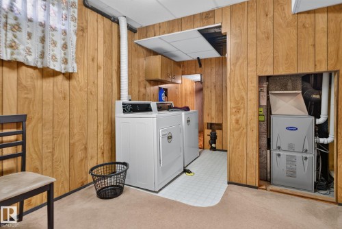 Laundry area featuring wood-panel walls and a built-in furnace enclosure - 6012 145 Avenue Nw, Edmonton, AB - Indoor Photo Showing Laundry Room