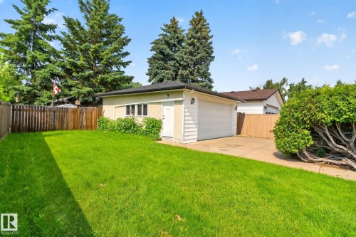 Detached garage with a white overhead door and side entry, featuring a paved driveway - 6012 145 Avenue Nw, Edmonton, AB - Outdoor