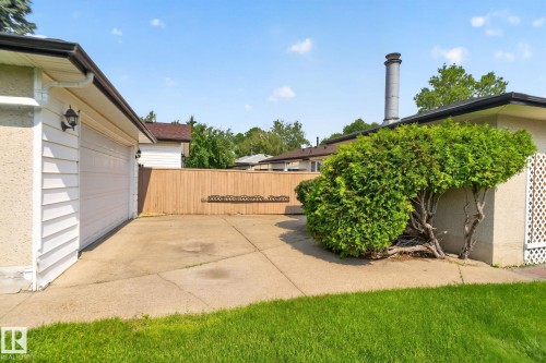 Concrete driveway leading to a single-car garage with horizontal white siding - 6012 145 Avenue Nw, Edmonton, AB - Outdoor With Exterior