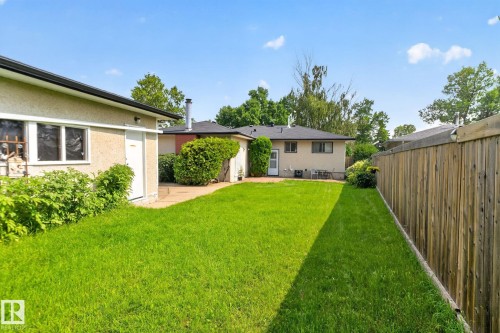 Expansive backyard featuring a manicured lawn, a full-height wooden privacy fence, and mature perimeter landscaping - 6012 145 Avenue Nw, Edmonton, AB - Outdoor