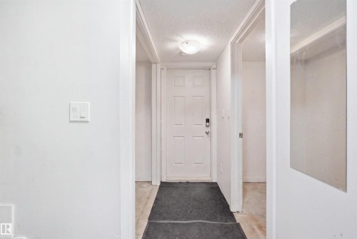 Entryway featuring a paneled door with modern hardware, ceiling-mounted light fixture, and light-colored flooring - #22 723 172 Street Sw, Edmonton, AB - Indoor Photo Showing Other Room