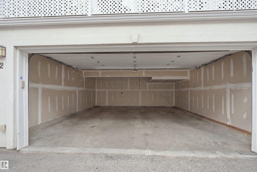 Spacious two-car garage with concrete flooring, drywall-finished walls, and overhead lighting - #22 723 172 Street Sw, Edmonton, AB - Indoor Photo Showing Garage