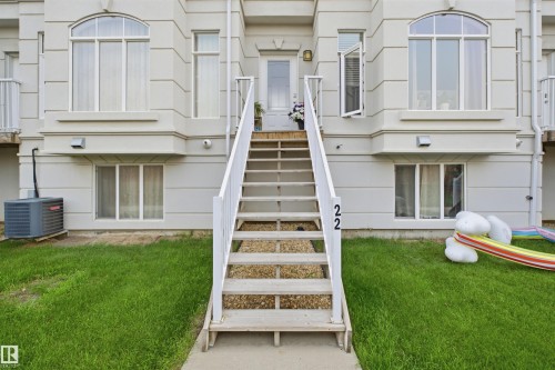 Exterior facade featuring a central staircase entry with white railings - #22 723 172 Street Sw, Edmonton, AB - Outdoor