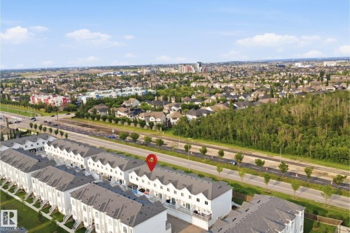 Aerial perspective showcasing a row of townhomes with white facades and dark sloped roofs - #22 723 172 Street Sw, Edmonton, AB - Outdoor With View